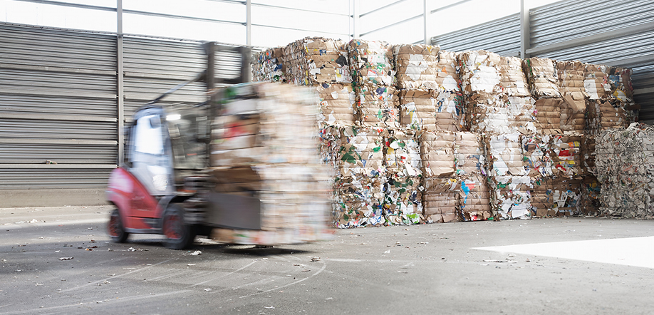 Jätteiden kierrätys ja jätteidenkeräys – Trukki lastaa jätepaaleja odottamaan omaa kuljetusvuoroaan Vantaan monimateriaaliyksikössä.